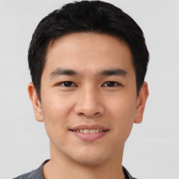 Joyful asian young-adult male with short  black hair and brown eyes