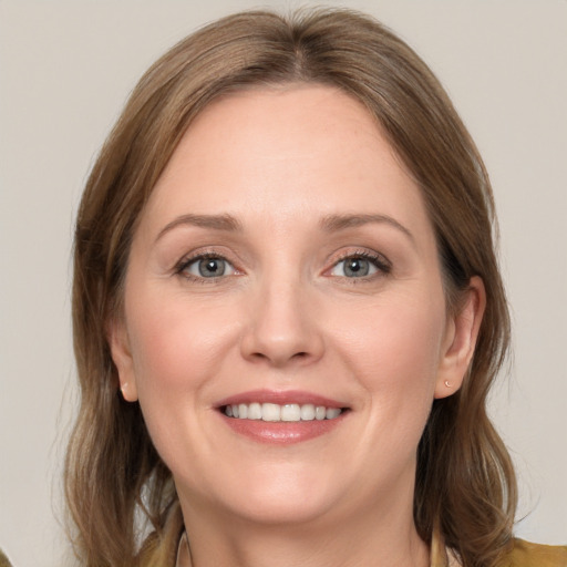 Joyful white adult female with medium  brown hair and grey eyes