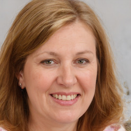 Joyful white adult female with medium  brown hair and blue eyes