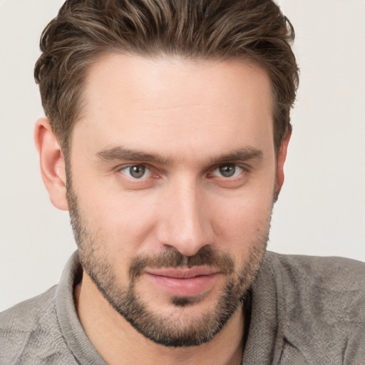 Joyful white young-adult male with short  brown hair and grey eyes