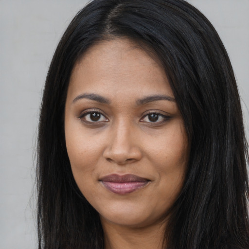 Joyful black young-adult female with long  black hair and brown eyes