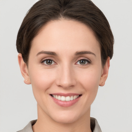 Joyful white young-adult female with short  brown hair and grey eyes