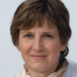 Joyful white adult female with medium  brown hair and grey eyes