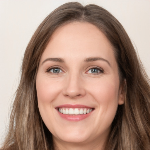 Joyful white young-adult female with long  brown hair and grey eyes