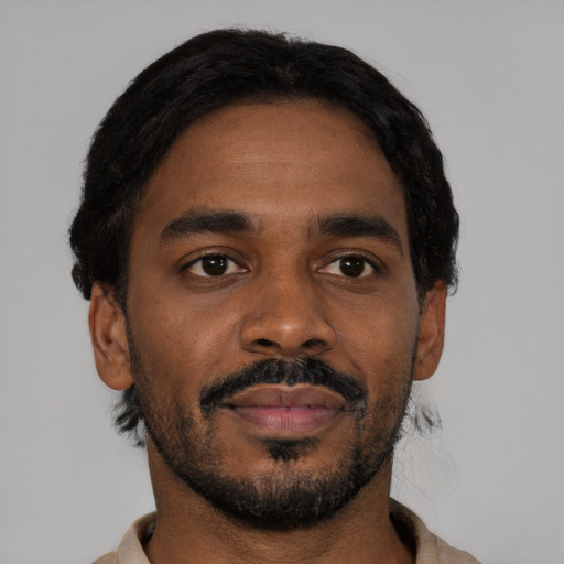 Joyful black young-adult male with short  black hair and brown eyes
