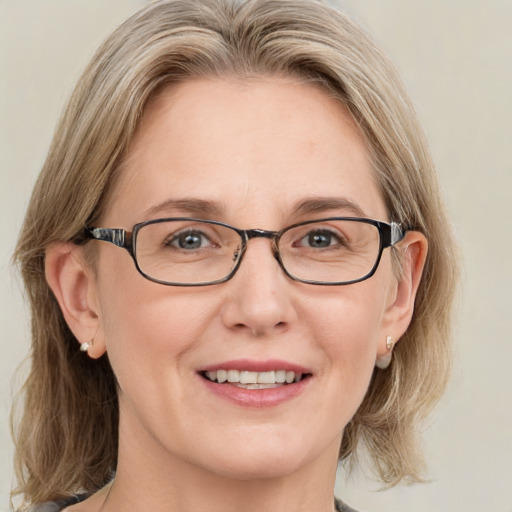 Joyful white adult female with medium  brown hair and blue eyes