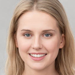 Joyful white young-adult female with long  brown hair and blue eyes