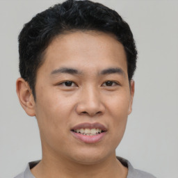 Joyful asian young-adult male with short  black hair and brown eyes