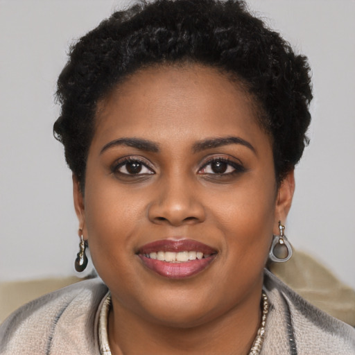 Joyful black young-adult female with short  brown hair and brown eyes