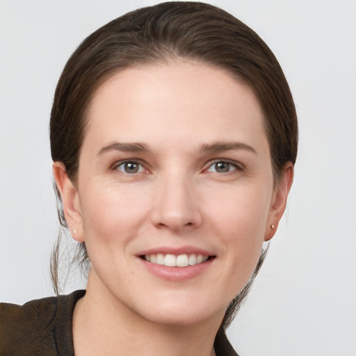 Joyful white young-adult female with medium  brown hair and grey eyes