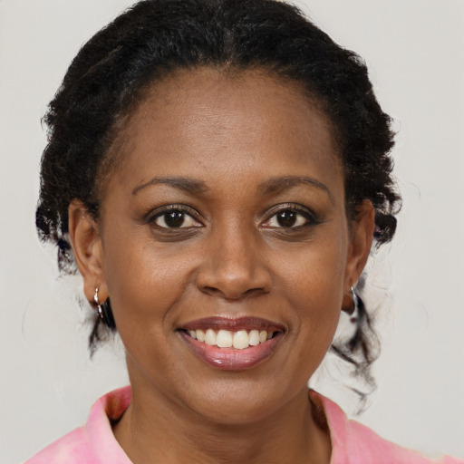 Joyful black adult female with medium  brown hair and brown eyes
