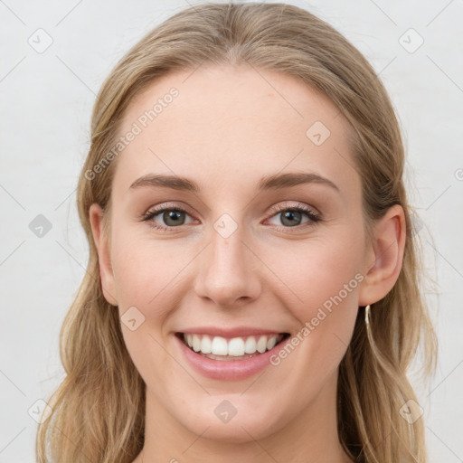 Joyful white young-adult female with long  brown hair and blue eyes