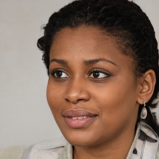 Joyful black young-adult female with short  black hair and brown eyes