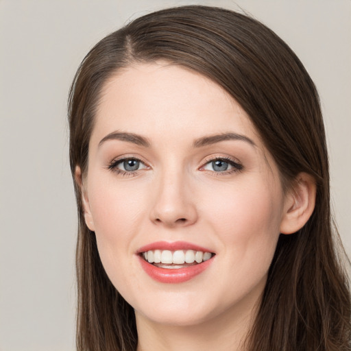 Joyful white young-adult female with long  brown hair and grey eyes