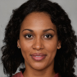 Joyful black adult female with long  brown hair and brown eyes