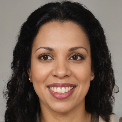 Joyful black young-adult female with long  brown hair and brown eyes
