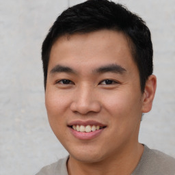 Joyful asian young-adult male with short  black hair and brown eyes