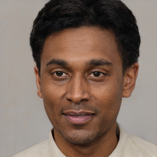 Joyful latino adult male with short  black hair and brown eyes