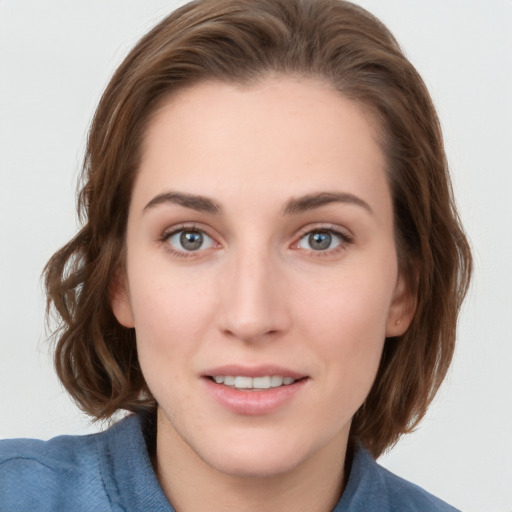 Joyful white young-adult female with long  brown hair and blue eyes