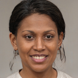 Joyful black adult female with medium  brown hair and brown eyes