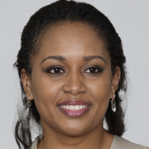 Joyful black adult female with long  brown hair and brown eyes