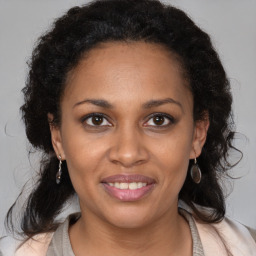 Joyful latino adult female with medium  brown hair and brown eyes