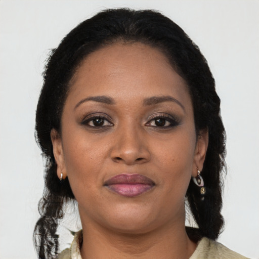 Joyful black adult female with long  brown hair and brown eyes
