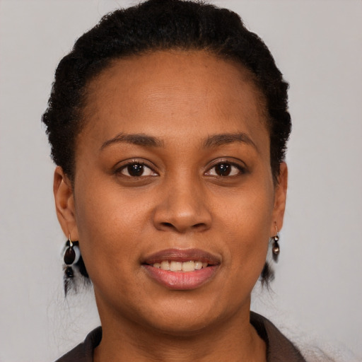 Joyful black young-adult female with short  brown hair and brown eyes