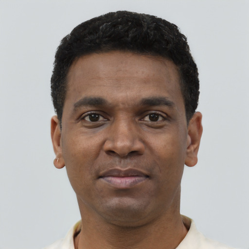 Joyful black young-adult male with short  brown hair and brown eyes