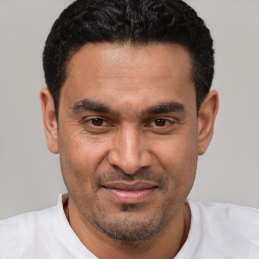Joyful latino adult male with short  black hair and brown eyes