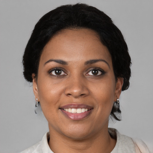 Joyful black young-adult female with short  black hair and brown eyes