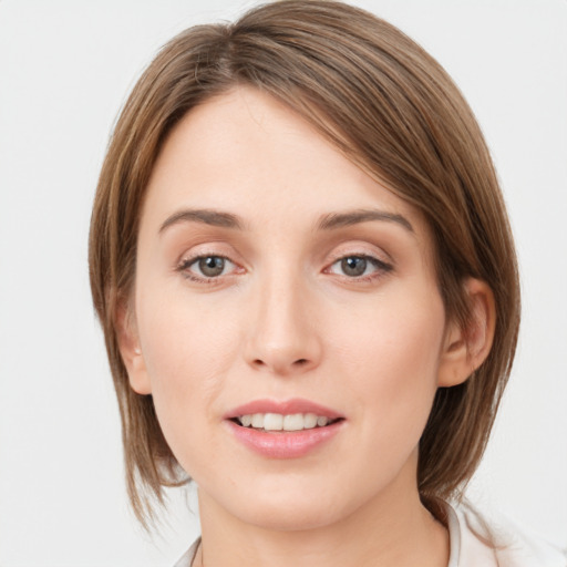 Joyful white young-adult female with medium  brown hair and grey eyes