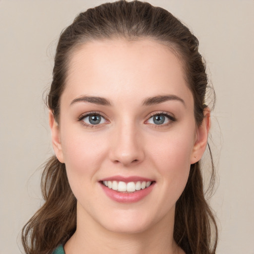 Joyful white young-adult female with long  brown hair and green eyes