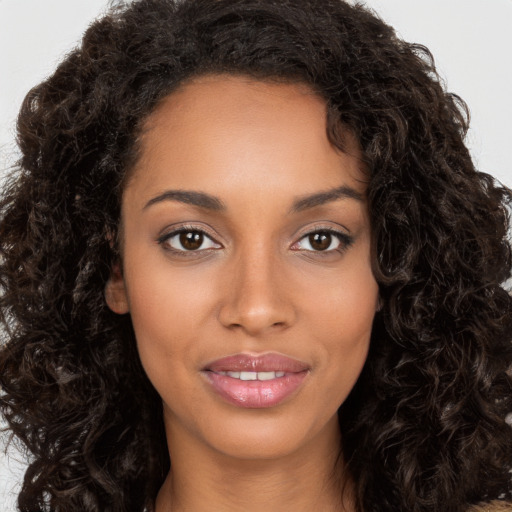 Joyful black young-adult female with long  brown hair and brown eyes