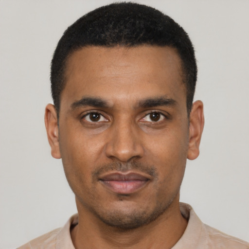 Joyful black young-adult male with short  black hair and brown eyes