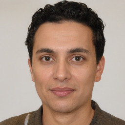 Joyful white young-adult male with short  black hair and brown eyes