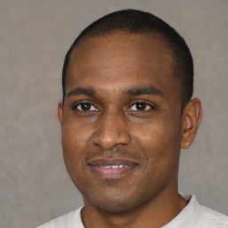 Joyful black young-adult male with short  brown hair and brown eyes