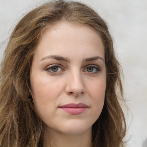 Joyful white young-adult female with long  brown hair and green eyes