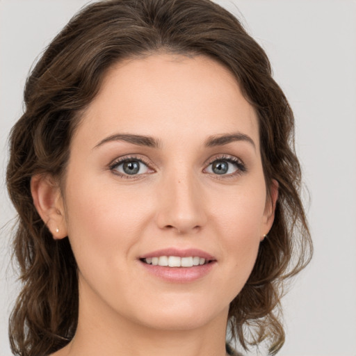 Joyful white young-adult female with medium  brown hair and grey eyes