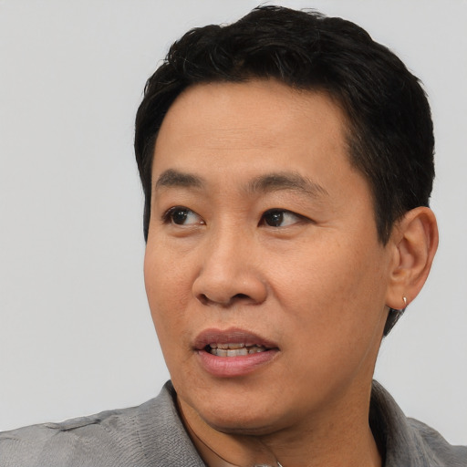 Joyful asian adult male with short  black hair and brown eyes