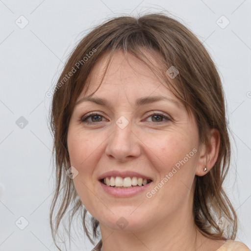 Joyful white adult female with medium  brown hair and grey eyes