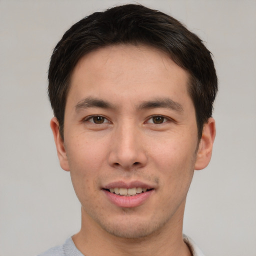 Joyful asian young-adult male with short  brown hair and brown eyes
