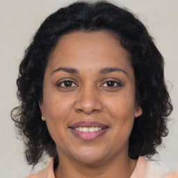 Joyful black adult female with medium  brown hair and brown eyes