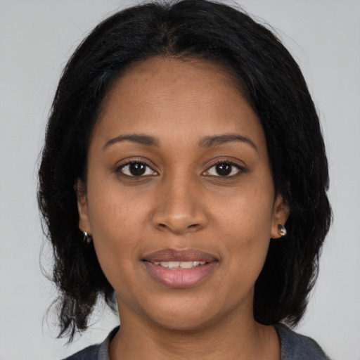Joyful black young-adult female with medium  black hair and brown eyes
