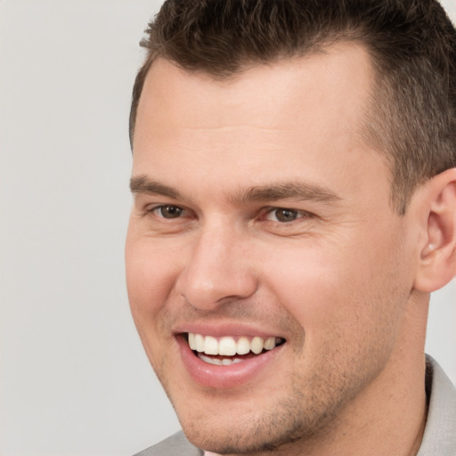 Joyful white young-adult male with short  brown hair and brown eyes