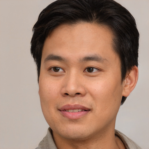 Joyful asian young-adult male with short  brown hair and brown eyes