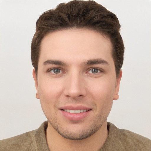 Joyful white young-adult male with short  brown hair and grey eyes