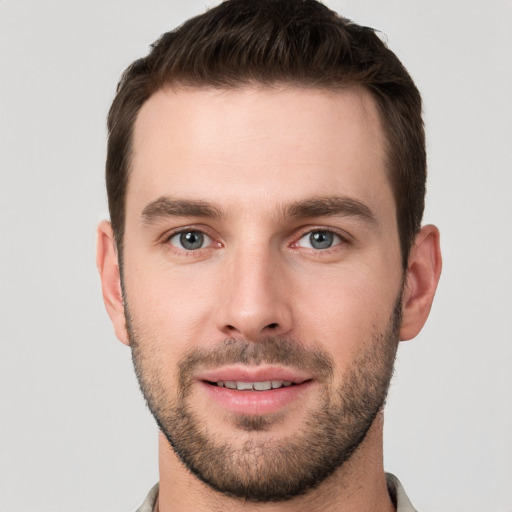 Joyful white young-adult male with short  brown hair and grey eyes