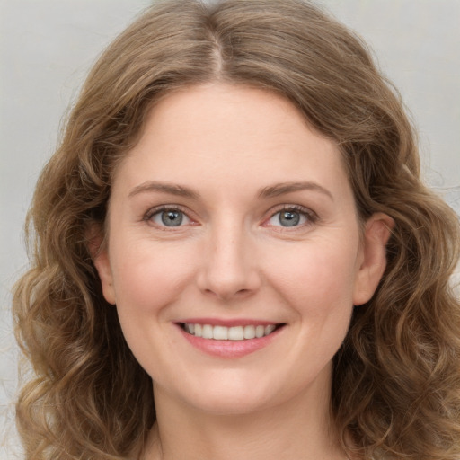 Joyful white young-adult female with long  brown hair and green eyes