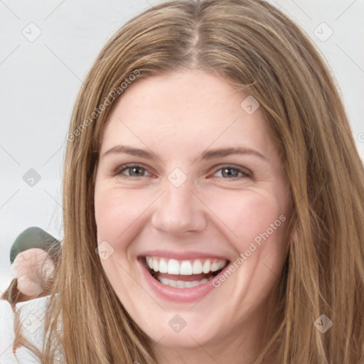 Joyful white young-adult female with long  brown hair and green eyes